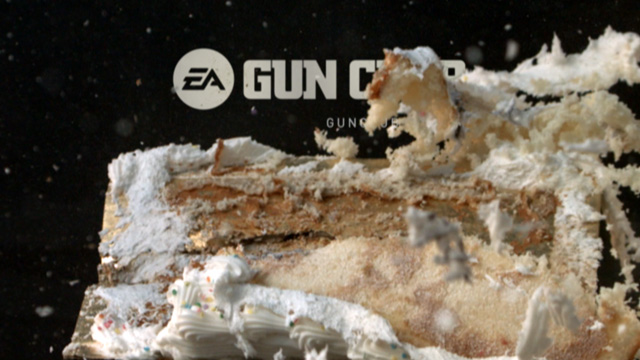 A piece of vanilla birthday cake is blasted with a shotgun, filmed in slow motion